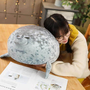 young woman sleeping on cute kawaii chonky seal plushie pillow with realistic print design