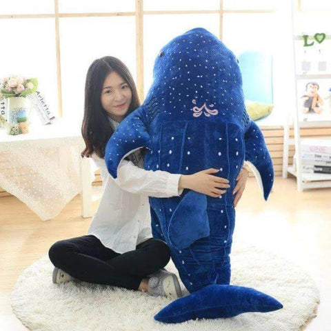 young woman hugging big huge XXL dark blue whale shark plushie pillows with open mouth