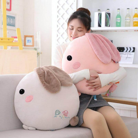 young woman cuddling pink and white gray cute kawaii chonky soft round bunny rabbit plushie pilow with fluffy floppy ears