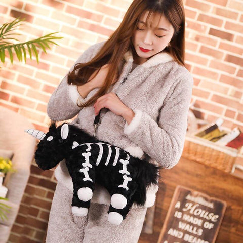 young woman looking stylish with her cute kawaii chonky fluffy Halloween black unicorn skeleton plushie handbag