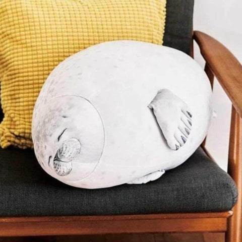 cute kawaii chonky seal plushie pillows with realistic print design sitting on chair