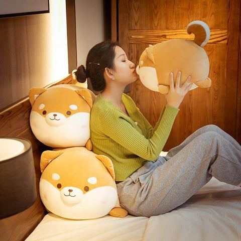young woman playing with orange brown cute kawaii fat chonky squishy soft shiba inu dog plushies