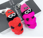 cute kawaii chonky pink and red cool caterpillar keyrings with sunglasses, beanie, and sweater on a bag