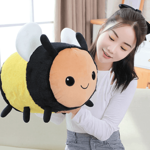 young woman playing with cute kawaii chonky bee plushie with wings and black and yellow stripes