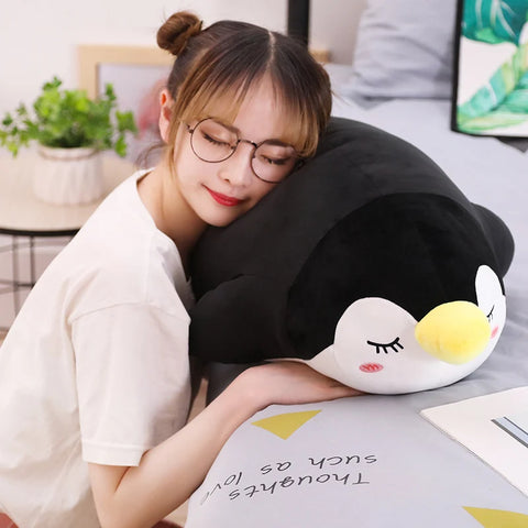 young woman sitting on black sleepy cute kawaii chonky penguin plushies lying down