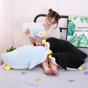 young woman cuddling sleepy cute kawaii chonky penguin plushies lying down