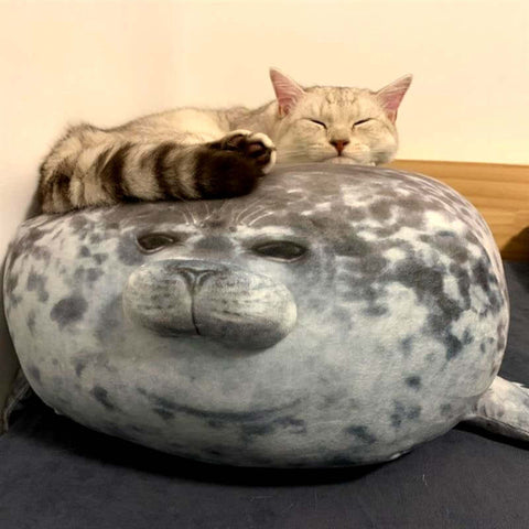 cat lying on cute kawaii chonky seal plushie pillow with realistic print design