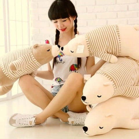 young woman hugging sleepy cute kawaii chonky bear plushies in sweater pullover lying down