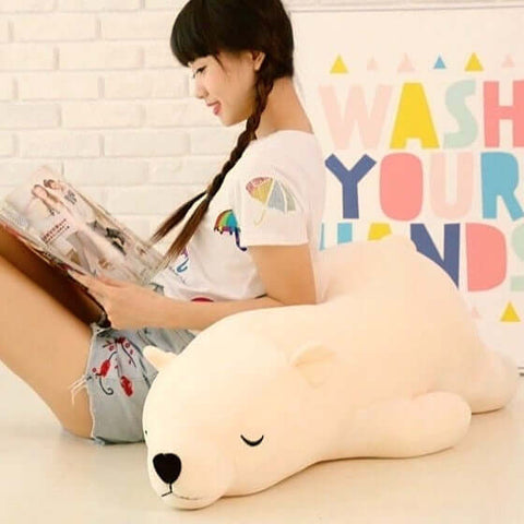 young woman sitting on white sleepy cute kawaii chonky bear plushie lying down