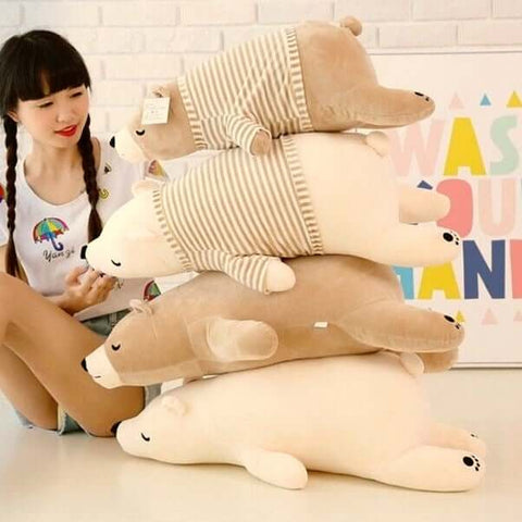 young woman playing with sleepy cute kawaii chonky bear plushies in sweater pullover lying down