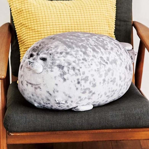 cute kawaii chonky seal plushie pillows with realistic print design sitting on chair