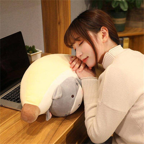 young woman sleeping on cute kawaii chonky banana gray cat plushie
