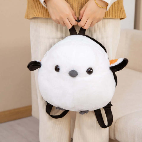 young woman holding white fluffy cute kawaii chonky sparrow bird plushie backpack bag with wings
