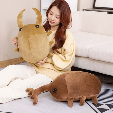 young woman cuddling cute kawaii chonky light brown stag beetle plushie with pincers