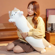 young woman holding big and long brown chonky cute kawaii cat plush dakimakura body pillow in bed