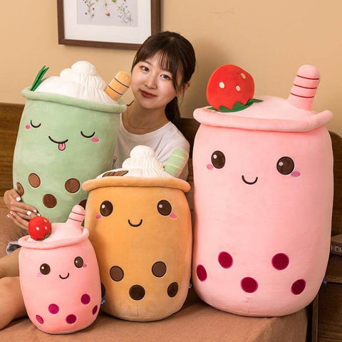 young woman playing with cute kawaii chonky bubble tea boba plushies with toppings (strawberry, coffee, and matcha flavor)