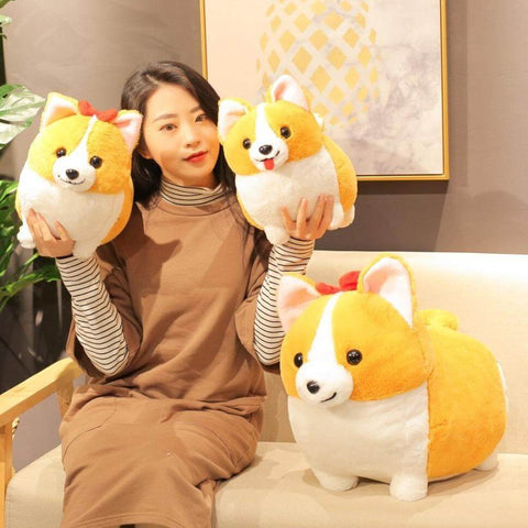 young woman playing with cute kawaii chonky fluffy orange corgi dog plushies