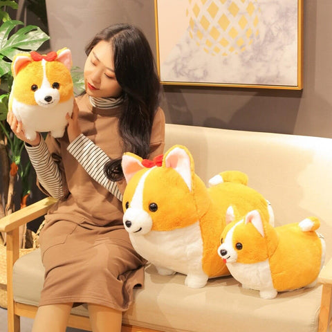 young woman cuddling with cute kawaii chonky fluffy orange corgi dog plushies