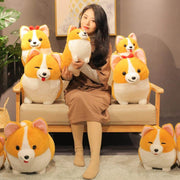 young woman playing with cute kawaii chonky fluffy orange corgi dog plushie family