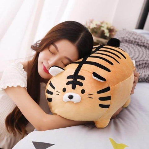 young woman sleeping on cute kawaii chonky squishy orange striped tiger plushie