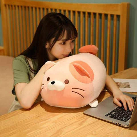 young woman napping on desk on cute kawaii chonky squishy soft kitty cat plushie