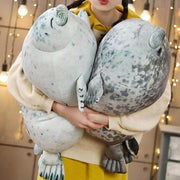young woman holding cute kawaii chonky seal plushie pillows with realistic print design