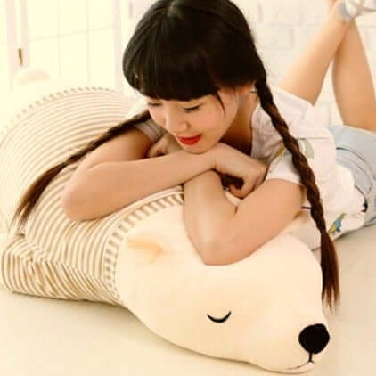 young woman sleeping on white sleepy cute kawaii chonky bear plushie in sweater pullover lying down