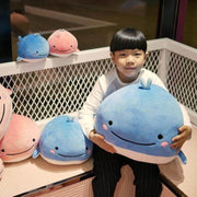 young boy playing with pink and blue cute kawaii chonky squishy round soft mochi whale plushies