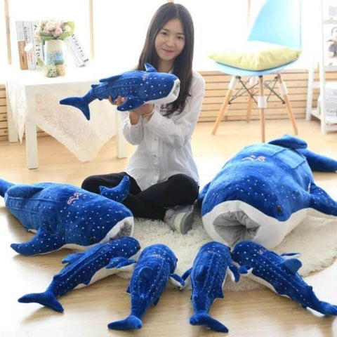 young woman cuddling big and small huge XXL dark blue whale shark plushie pillows with open mouth