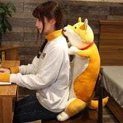 young woman sitting on chair with big orange cute kawaii chonky shiba inu dog plushie