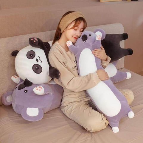 Young woman hugging long cute kawaii chonky koala and panda bear dakimakura plushie body pillows in bed