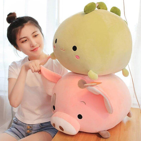 young woman playing with cute kawaii chonky soft squishy round mochi pink pig and green dinosaur dino plushies