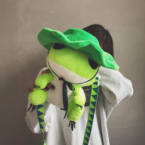 young woman holding cute kawaii chonky green frog bag with green hat
