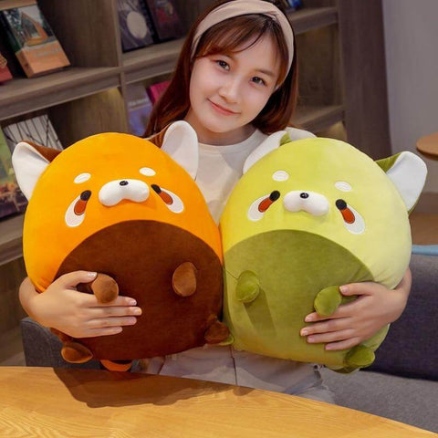 young woman holding cute chonky orange and green racoon plushies in a living room