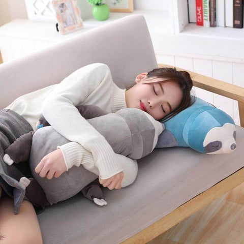 young woman sleeping with sleepy cute kawaii chonky sloth plushies lying down