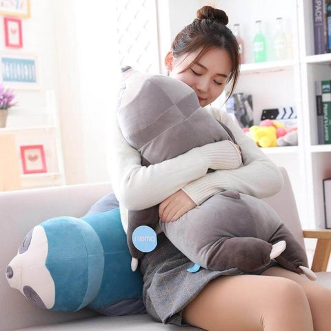 young woman hugging sleepy cute kawaii chonky sloth plushies lying down