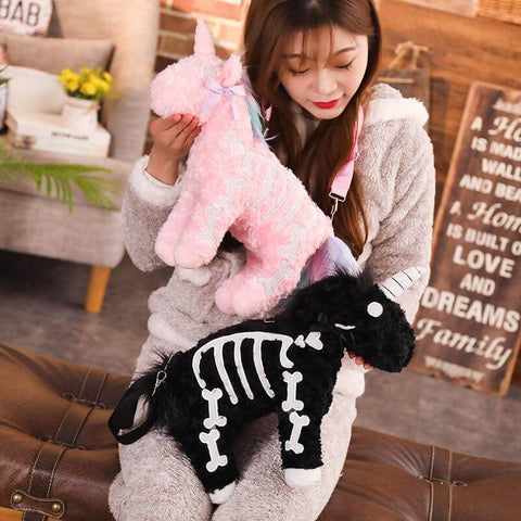 young woman cuddling cute kawaii chonky fluffy Halloween black and pink unicorn skeleton plushie handbags