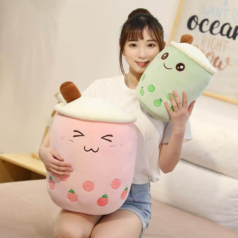 young woman playing with cute kawaii chonky big and small pink strawberry and green apple fruit bubble tea boba plushies