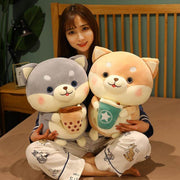 young woman holding gray and orange cute kawaii chonky shiba inu dog plushies with bubble tea
