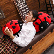 young woman cuddling with cute kawaii chonky soft round mochi ladybug plushie pillows