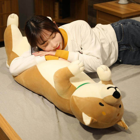 young woman lying on big brown cute kawaii chonky shiba inu dog plushie