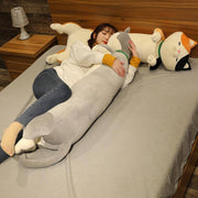 young woman hugging and cuddling big gray cute cawaii chonky cat plushie body pillow in bed