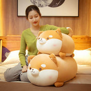young woman relaxing in bed with orange brown cute kawaii fat chonky squishy soft shiba inu dog plushies