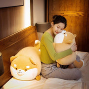 young woman hugging orange brown cute kawaii fat chonky squishy soft shiba inu dog plushies