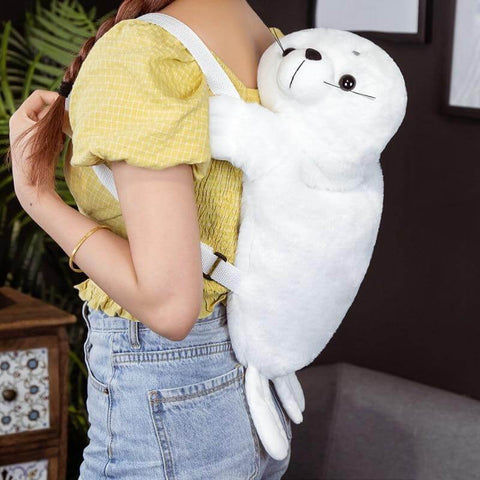 young woman wearing white fluffy cute kawaii chonky seal plushie backpack bag