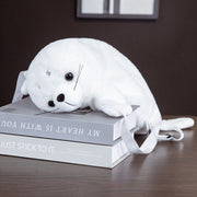 white fluffy cute kawaii chonky seal plushie backpack bag lying on table