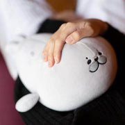 young woman cuddling with cute kawaii chonky gray seal plushie