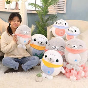 young woman playing with cute kawaii chonky soft squishy gray and white seal plushies with bandanas