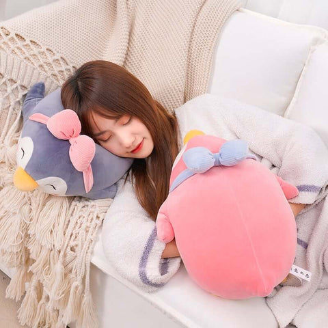woman sleeping on cute kawaii chonky gray penguin hand warmer plushie
