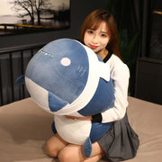 young woman holding cute kawaii chonky blue black shark plushie with white scarf